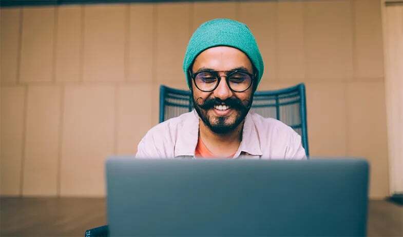 A linguist smiles as he reviews a translation job.